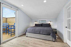 A bedroom with a bed, a sliding glass door leading to an outdoor area, and a small desk with a chair. - Newly remodeled 5BR farmhouse in Coloma, just 8 minutes to Lake Michigan beach. Enjoy 3,000 sq ft, 2 full baths, smart TVs in every bedroom, a covered deck, large yard, and private balcony off the primary suite. (Coloma)