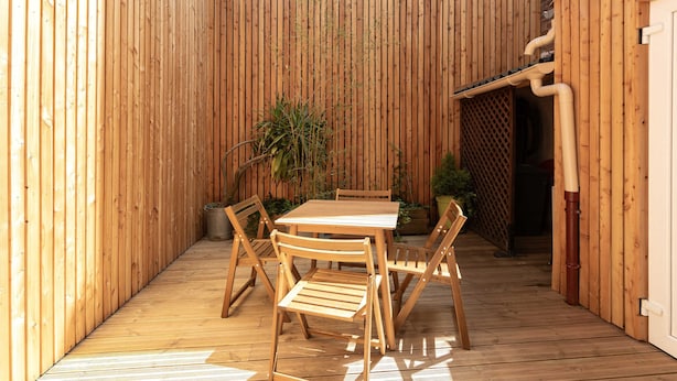 A wooden deck with a table and chairs, surrounded by vertical wooden panels. - Rez-de-chaussee de la Mairie - Clim - Terrasse (Arras)
