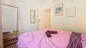 A bedroom with a bed, a wardrobe, a door, and two framed pictures on the wall. - Rez-de-chaussee de la Mairie - Clim - Terrasse (Arras)