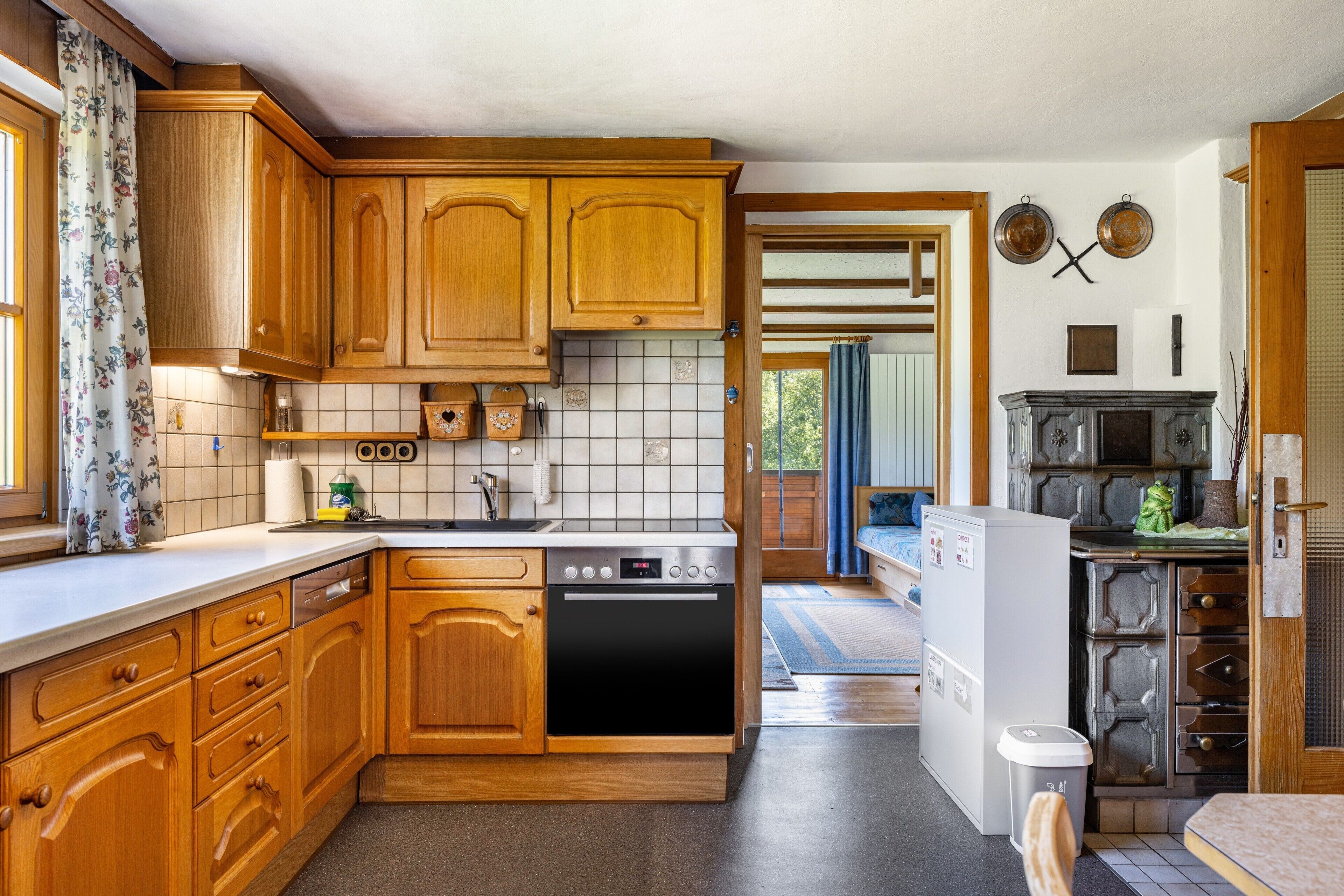 Une cuisine avec des meubles de rangement en bois, un lave-vaisselle, un réfrigérateur et un four à micro-ondes.