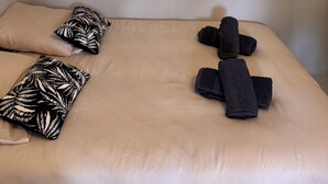 A hotel room with a bed, pillows, towels, and three framed pictures on the wall. - Studio in the Heart of Provence (Châteaurenard)
