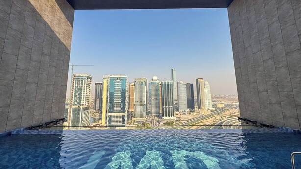 Ein Pool im Infinity-Design mit Blick auf die Stadtlandschaft.