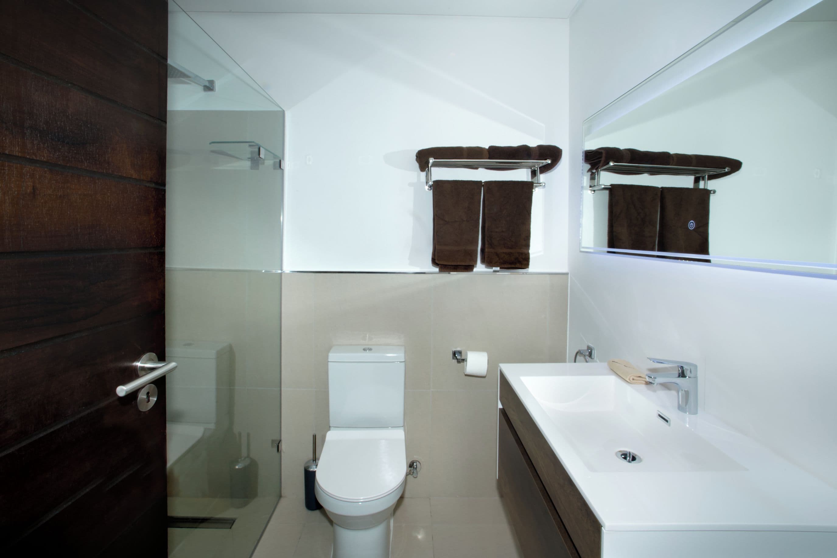 Un bagno moderno con un water, un lavandino e una cabina doccia in vetro.