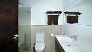 Un bagno moderno con un water, un lavandino e una cabina doccia in vetro.