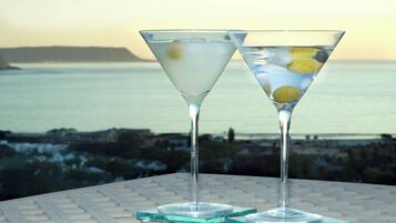 Two martini glasses with a coastal view in the background.
