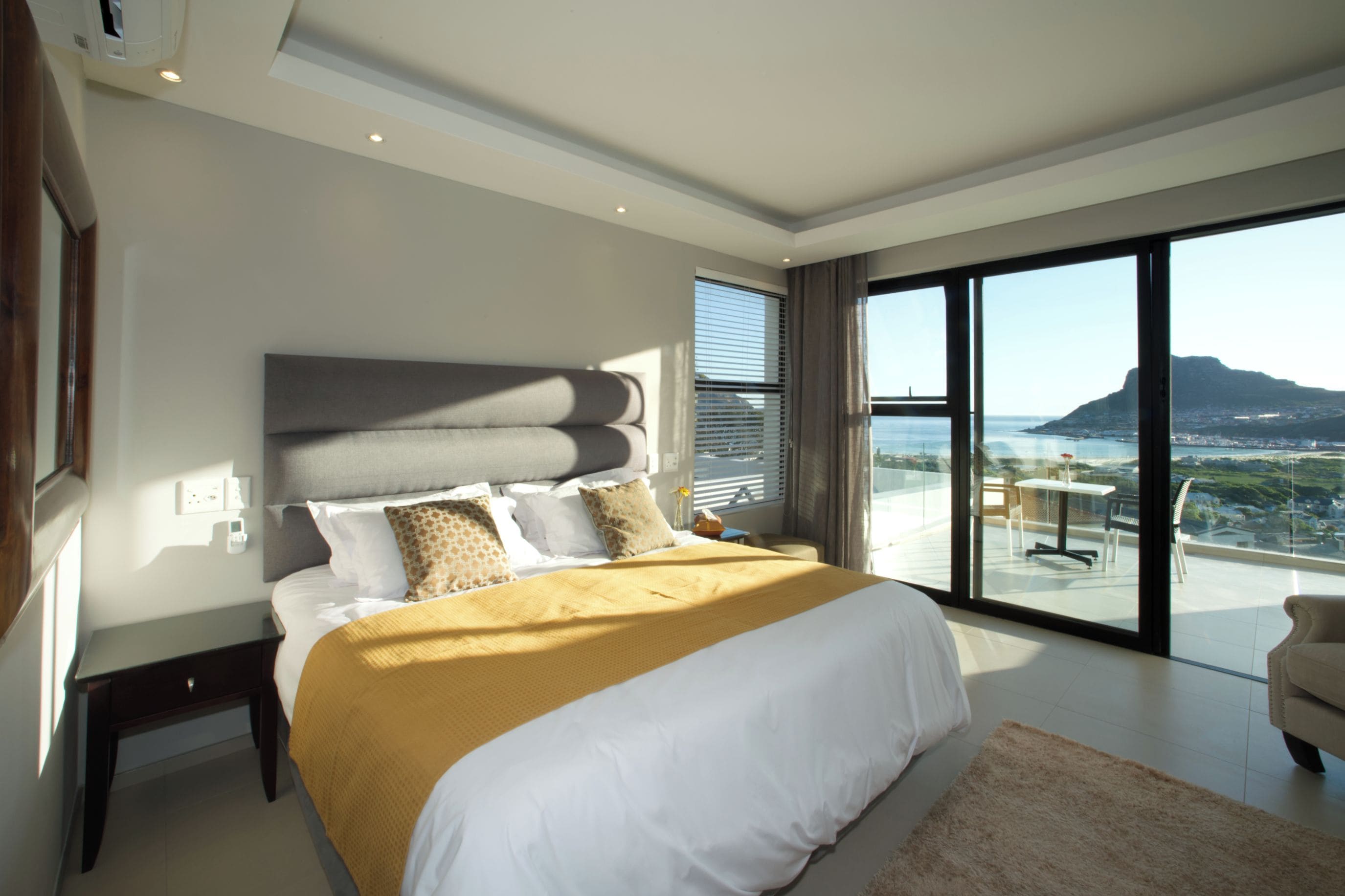 Une chambre moderne avec un grand lit, une vue sur la ville et un balcon.
