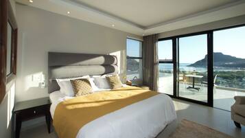 Une chambre moderne avec un grand lit, une vue sur la ville et un balcon.