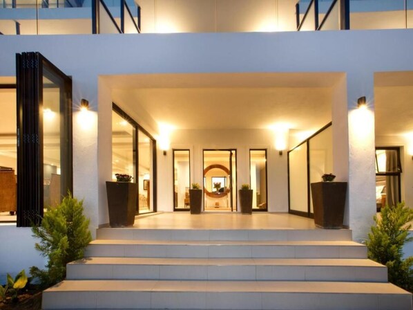 A modern building entrance with a staircase leading to a reception area.