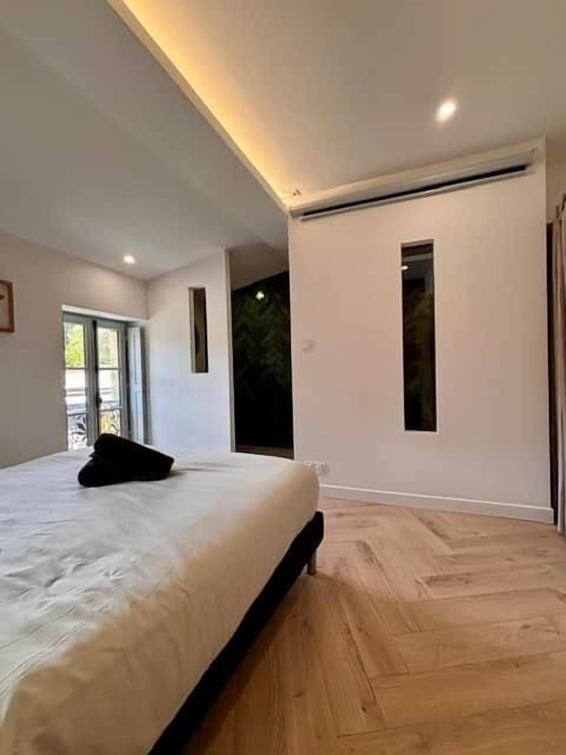 A bedroom with a bed, a window, and a door.