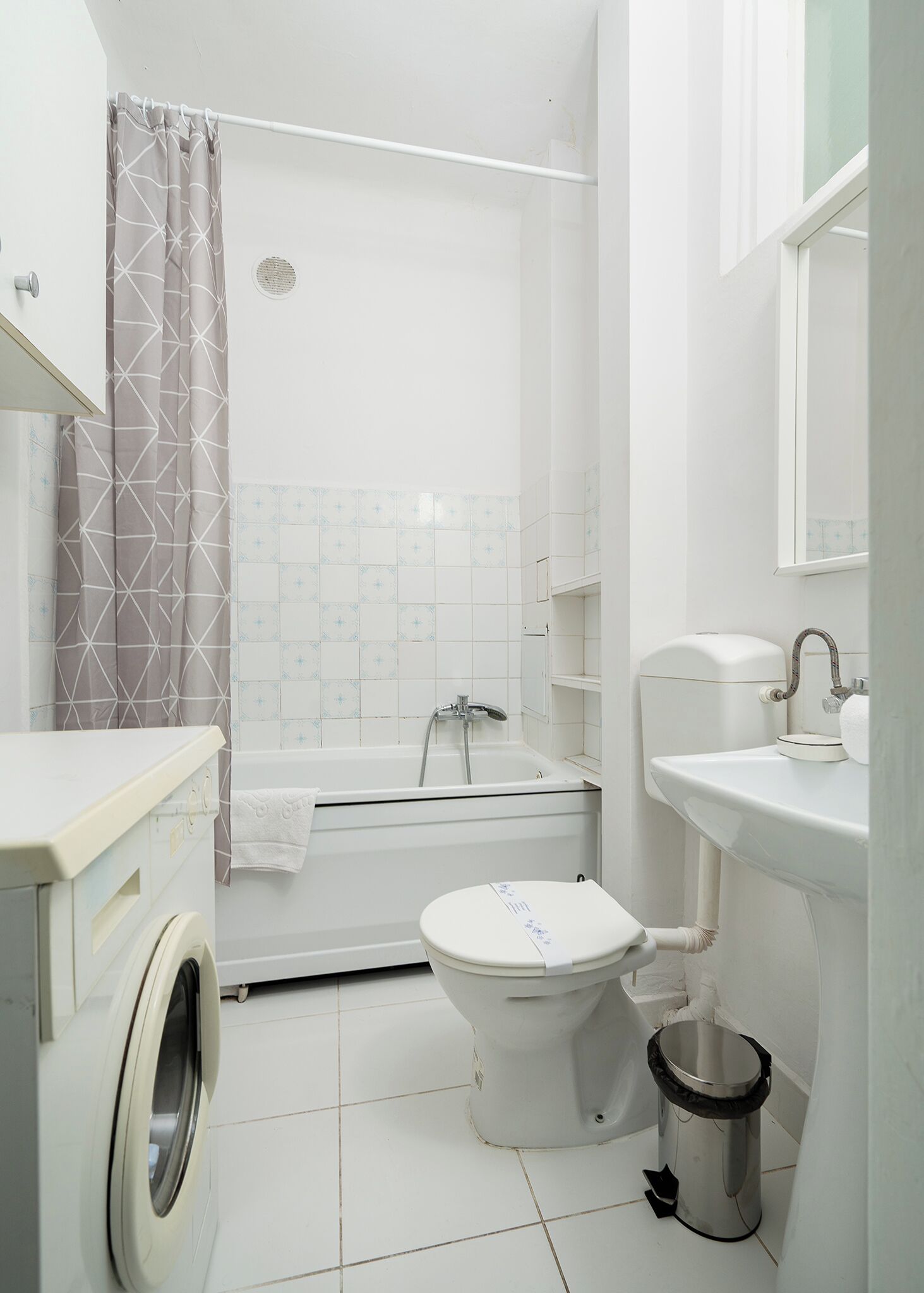 Une salle de bain équipée de toilettes, d’un lavabo, d’une douche et d’un lave-linge.