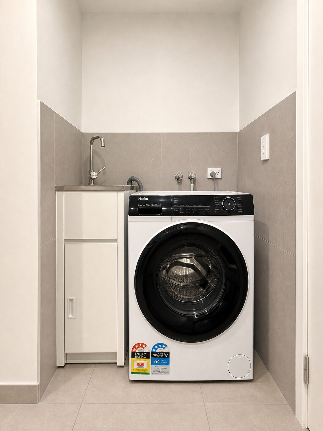 Ein kleiner Hauswirtschaftsraum mit einer Waschmaschine mit Frontlader und einem Schrank.