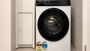 Ein kleiner Hauswirtschaftsraum mit einer Waschmaschine mit Frontlader und einem Schrank.
