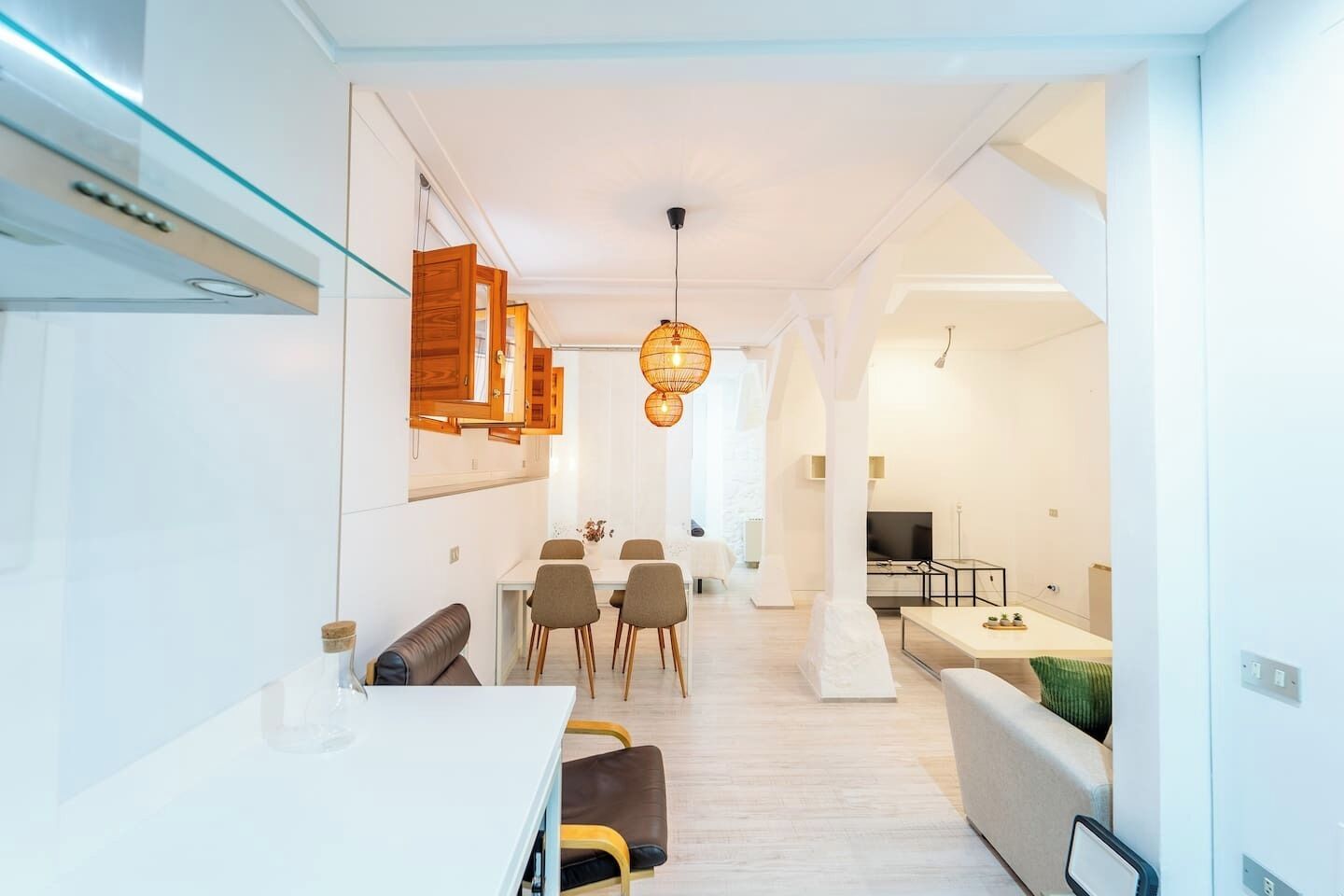 Un interior moderno con comedor, sofá y televisión.
