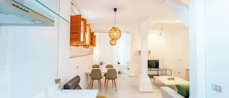 A modern interior with a dining area, a sofa, and a TV.