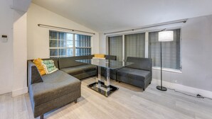 A modern living room with a glass-top table, grey sofas, and a floor lamp. - 3 Mi to Hollywood Beach! Canal-front Haven w/ Dock (Hollywood)