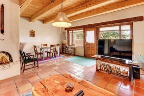 Ein Wohnzimmer mit Kamin, Holzmöbeln, einem Fernseher und einem Bücherregal.