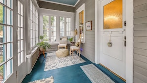 A hallway with large windows, a blue floor, and a door with a golden glass panel. - 4BR Historic Home Located in Downtown New Bern (New Bern)