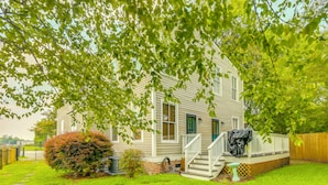 A single-story house with a front porch, a small front yard, and a wooden fence. - 4BR Historic Home Located in Downtown New Bern (New Bern)
