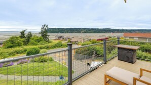 A deck with a bench and a table, overlooking a residential area with houses and a body of water. - Hot Tub & Puget Sound View! Whidbey Island Retreat (Clinton)