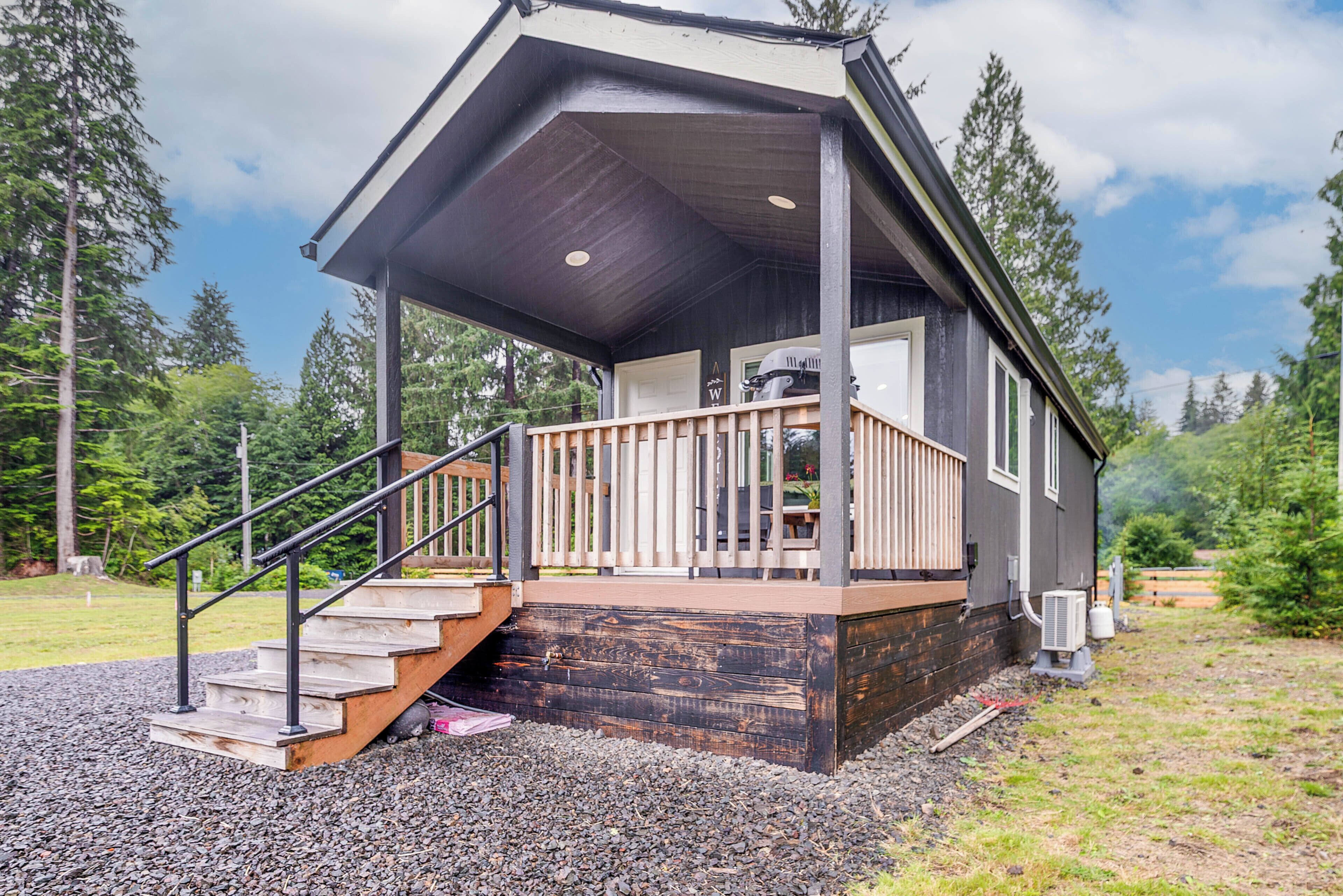 A wooden cabin with a porch, a staircase, and a small deck.