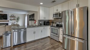 A modern kitchen with stainless steel appliances, white cabinetry, and a wood floor. - 4 Mi to Dtwn: Garland Getaway w/ Fenced-in Yard (Garland)