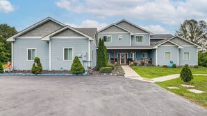 A two-story house with a front porch, a driveway, and a well-maintained lawn.