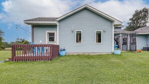 A light blue house with a front porch and a small deck.