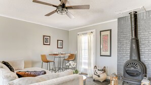 A living room with a fireplace, a ceiling fan, and a dining area with chairs and a table. - Group Entertainment Oasis! 3-unit Lithonia Getaway (Lithonia)