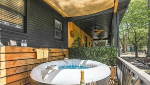A hot tub with a wooden deck, a bottle of champagne, and two glasses on a table. - Group Entertainment Oasis! 3-unit Lithonia Getaway (Lithonia)