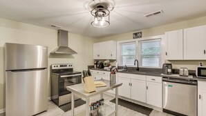 A modern kitchen with stainless steel appliances, a central island, and white cabinetry. - 4 Mi to Dtwn! 'carolyn's Cottage' in Decatur (Decatur)