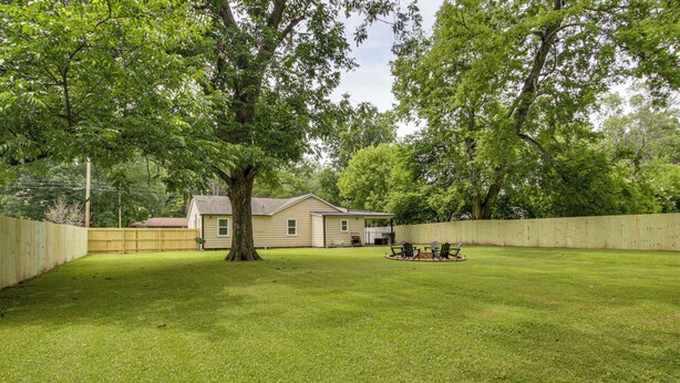 A backyard with a house, a wooden fence, a tree, and a lawn. - 4 Mi to Dtwn! 'carolyn's Cottage' in Decatur (Decatur)