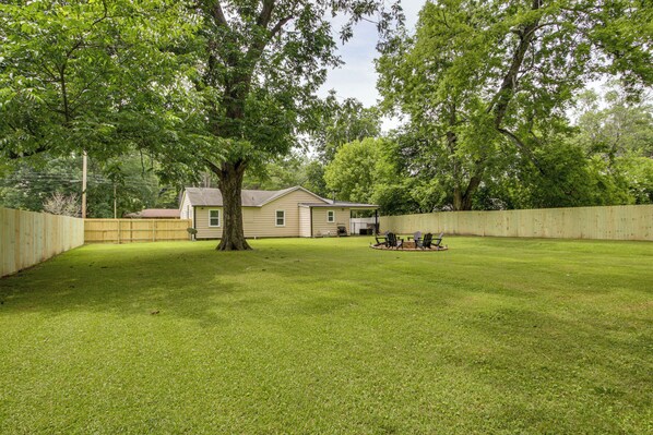 A backyard with a house, a wooden fence, a tree, and a lawn. - 4 Mi to Dtwn! 'carolyn's Cottage' in Decatur (Decatur)