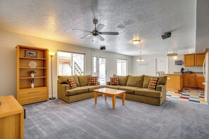 Un salon avec un canapé, une table basse et un ventilateur de plafond.