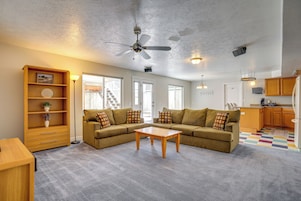 A living room with a sofa, coffee table, and a ceiling fan.