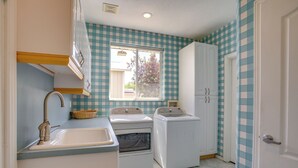 A laundry room with a sink, two washing machines, and a window. - Near Hill Afb! Dual-unit Home w/ Deck & Patio (Clearfield)