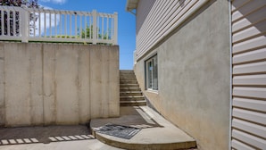 A concrete staircase leading to a building with a white exterior and a white fence. - Near Hill Afb! Dual-unit Home w/ Deck & Patio (Clearfield)