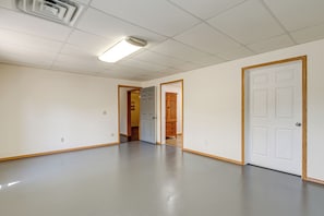 A hallway with a polished floor, white walls, and wooden-framed doors. - 8 Mi to Nat'l Military Park: Rural Pea Ridge Base (Pea Ridge)