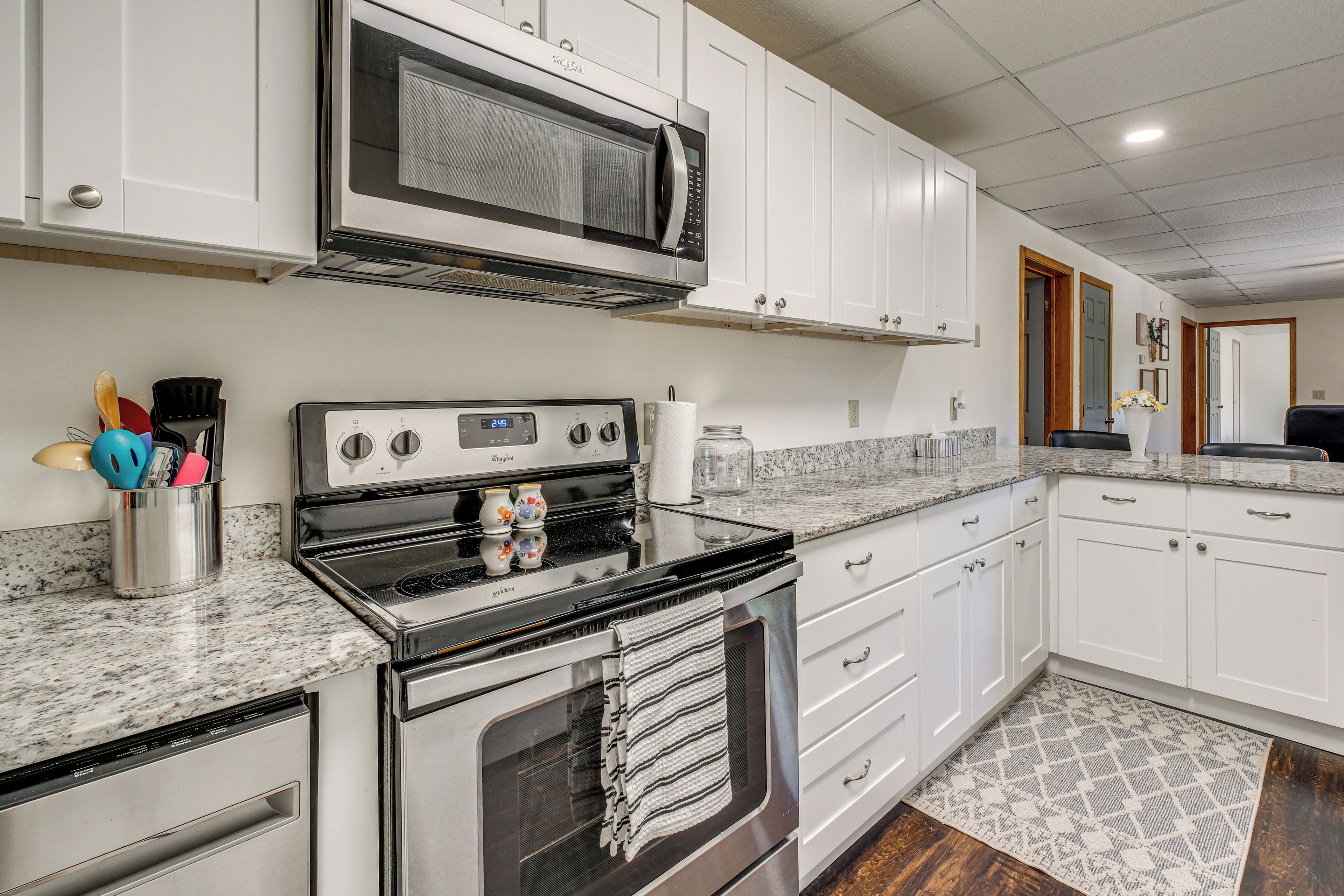 A kitchen with white cabinets, a microwave, a stove, and a dishwasher.