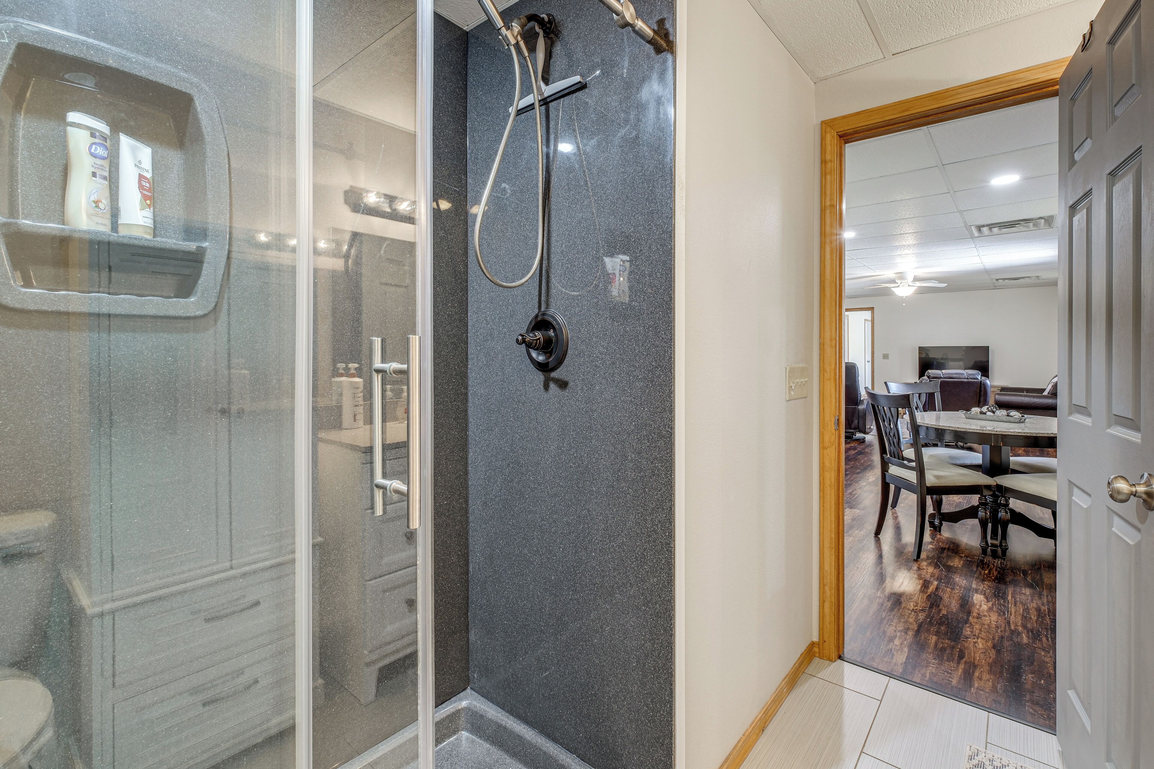 Ein Badezimmer mit Duschkabine aus Glas, einer Handbrause und einer Toilette.