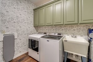 A laundry area with a washer and dryer, a sink, and green cabinets. - 8 Mi to Bentonville: Serene Retreat on 8 Acres (Pea Ridge)