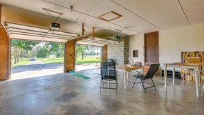 A spacious garage with a concrete floor, a brick wall, and a wooden door. - Peaceful Fulton Farm Retreat w/ Outdoor Space! (Fulton)