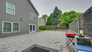 A backyard with a grill, a lantern, and a blue bench. - Walk to Train! Updated Apt in Huntington Station (Huntington Station)