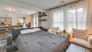 A modern hotel room with a large bed, a desk, a chair, and a mirror. - Walk to Train! Updated Apt in Huntington Station (Huntington Station)
