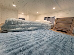 A bedroom with a bed, a wooden dresser, and a ceiling with recessed lighting. - Oceanfront Tiny Retreat On Wheels, Fall Package + 2 Bikes (Holden Beach)