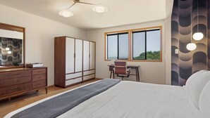 Quarto com cama, penteadeira, escrivaninha e guarda-roupa.