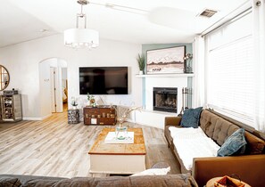 Ein Wohnzimmer mit Kamin, Fernseher und einer Couch.