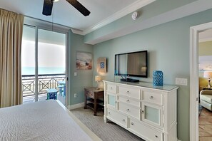 A bedroom with a bed, a dresser, a television, and a desk with a lamp. - Azure #306 | Gulf Front Condo with Stunning Views and Resort Amenities (Fort Walton Beach)