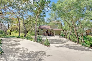 A house with a covered porch, surrounded by trees and a paved driveway. - Westview Lookout | Panoramic Lake Views, Decks & Near Boat Ramp (Canyon Lake)