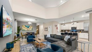 Een moderne woonkamer met een bank, stoelen, een salontafel en een eethoek met een tafel en stoelen.