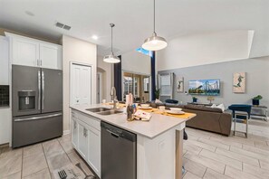 A modern kitchen with a central island, stainless steel appliances, and pendant lighting. - Private Pool+Spa*Games Room*Clubhouse Amenities (Kissimmee)